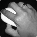 black and white image of a hand over a computer mouse